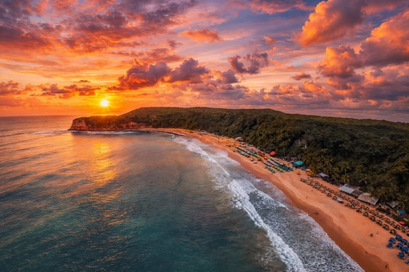 Praia do madeiro en Pipa en el atardecer con colores amarillos y anaranjados en el cielo
