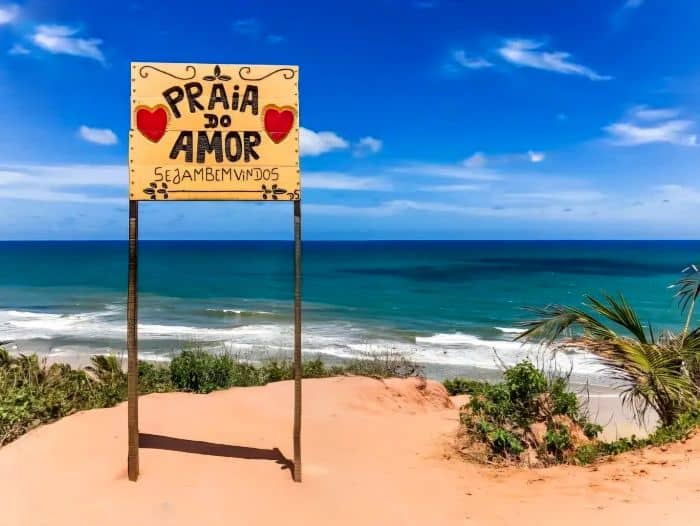 Vista panorámica de la Praia do Amor en Pipa, Brasil, con sus acantilados y cartel con corazones