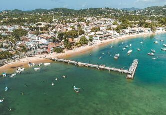 Vista panorámica de una de las playas más lindas de Búzios, Brasil, con aguas cristalinas y barquitos en la costa