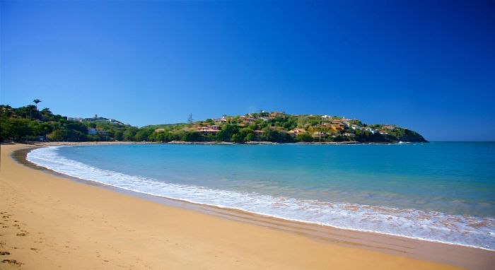 Praia da Ferradura en Búzios: amplia bahía de aguas calmas y azules, rodeada de colinas verdes y casas de veraneo.