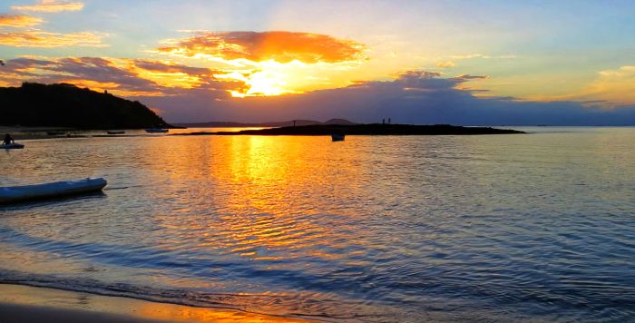 Atardecer en Praia da Tartaruga, Búzios: cielo anaranjado reflejado sobre aguas tranquilas y cálidas