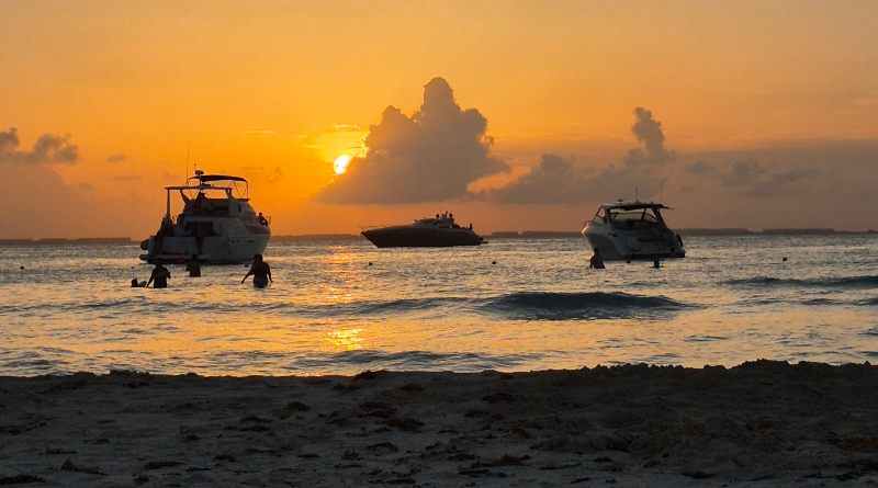 atardecer playa norte con colores anaranjados de fondo y barcos sobre el mar