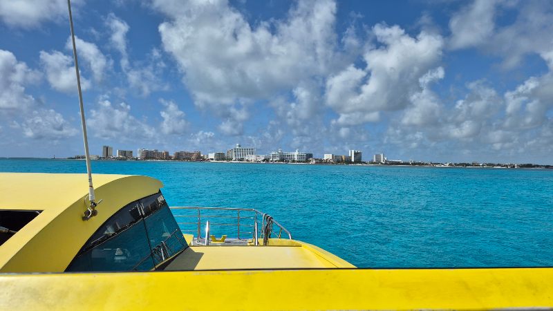 Vista desde la terraza del ferry rumbo a Isla Mujeres, con el mar turquesa y cielo despejado al fondo